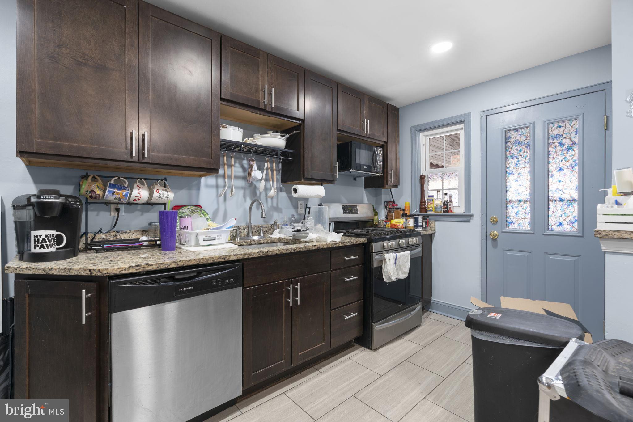 514 Umbra Street Baltimore, MD 21224 - Photo 12 of 37 a kitchen with stainless steel appliances granite countertop a sink stove and cabinets