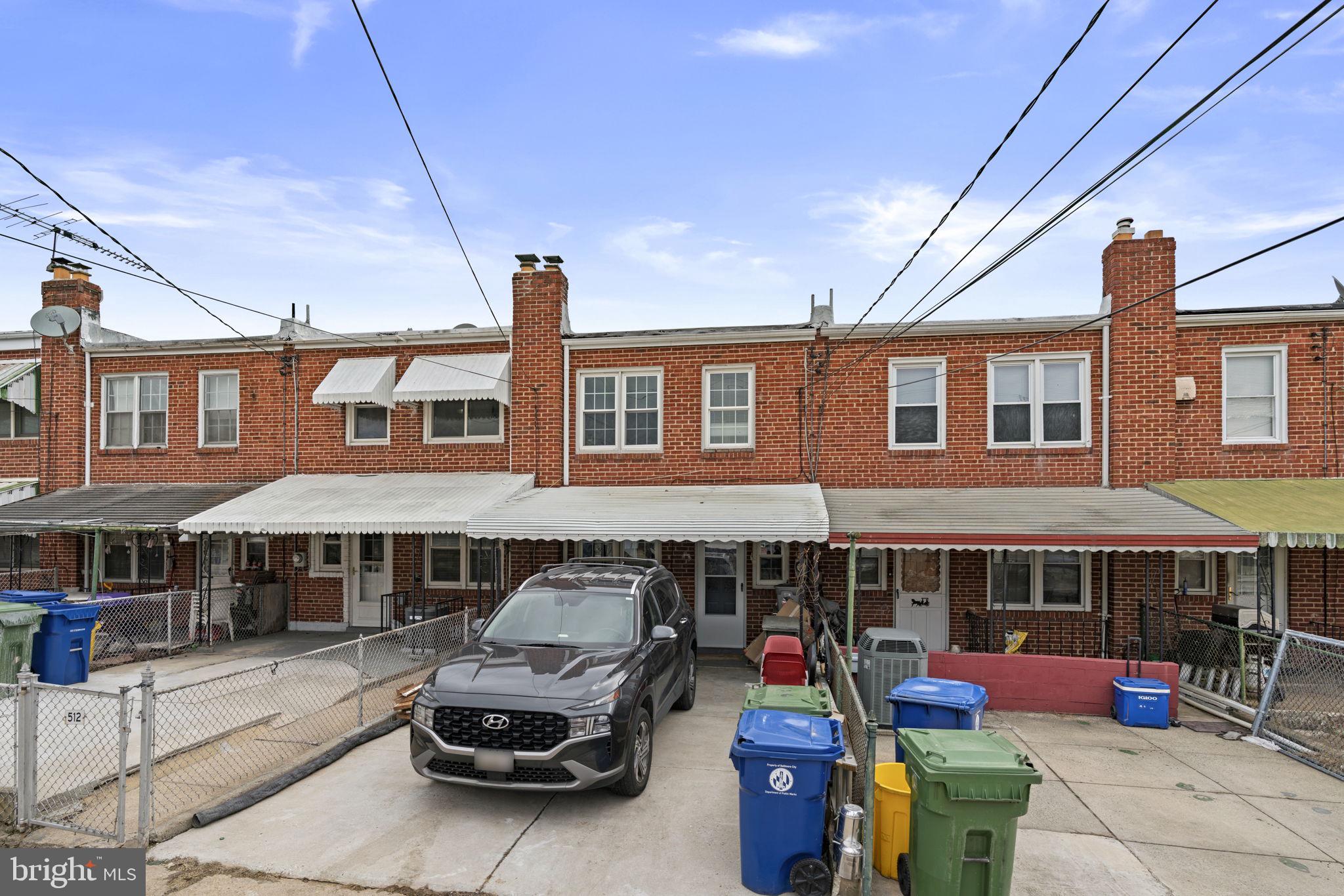 514 Umbra Street Baltimore, MD 21224 - Photo 31 of 37 a car parked in front of a brick house