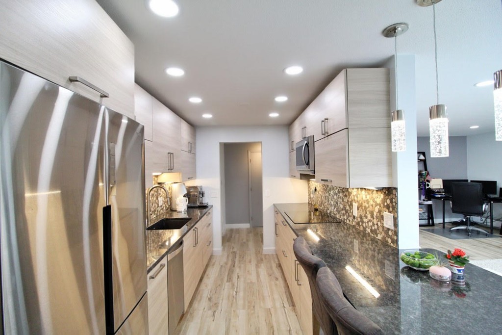 1206 Greendale Avenue, Unit 201 Needham, MA 02492 - Photo 3 of 26 a kitchen with stainless steel appliances a refrigerator and a view of living room