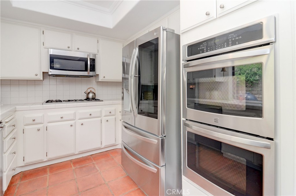 25095 Perch Drive Dana Point, CA 92629 - Photo 13 of 30 a kitchen with stainless steel appliances white cabinets and a stove top oven