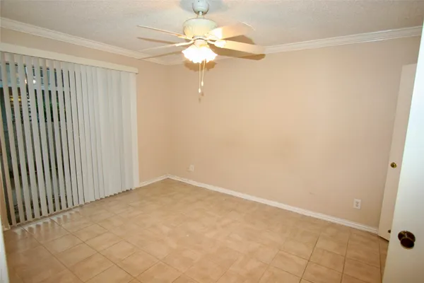 en empty room with windows and chandelier fan