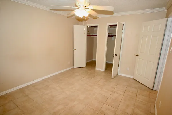 an empty room with closet and a chandelier fan