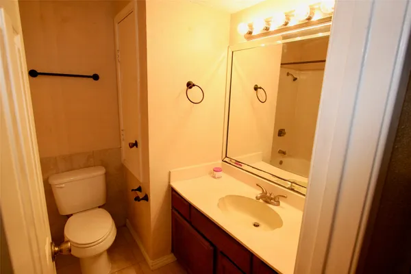 a bathroom with a granite countertop toilet sink and shower
