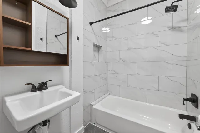 a white bath tub sitting next to a white sink and vanity