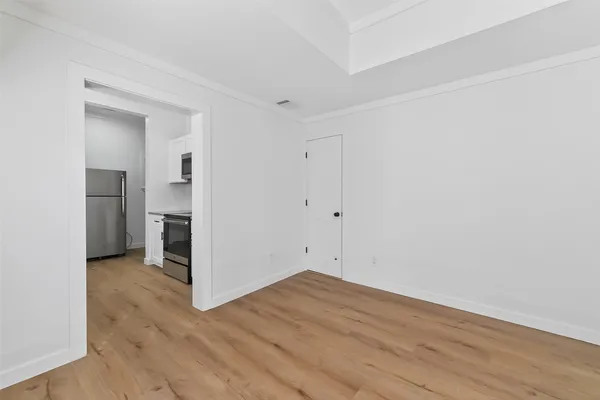 a view of empty room with wooden floor