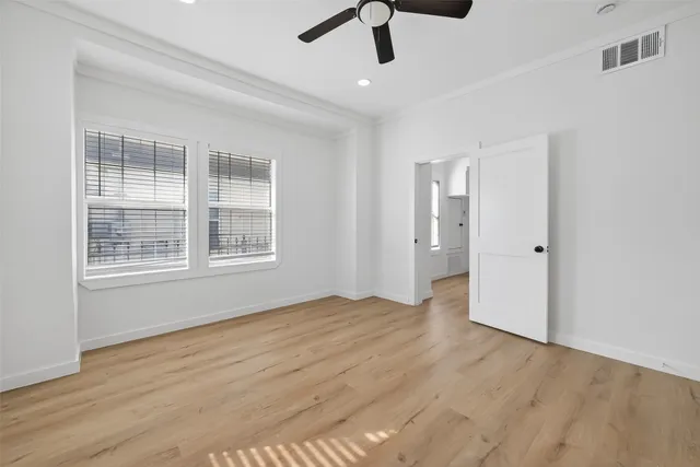 a view of an empty room with a window and wooden floor