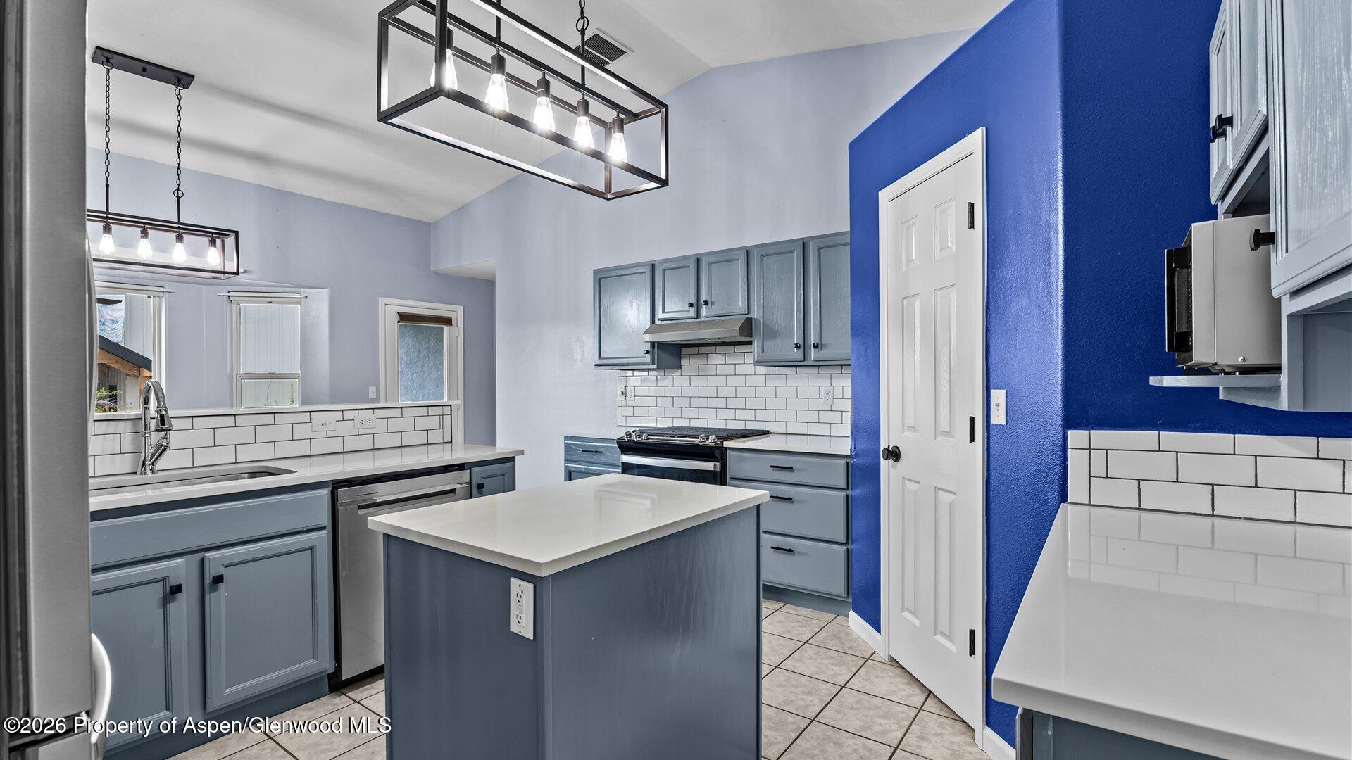 1459 Anvil View Avenue Rifle, CO 81650 - Photo 10 of 29 a kitchen with a sink dishwasher a stove and a refrigerator with wooden floor