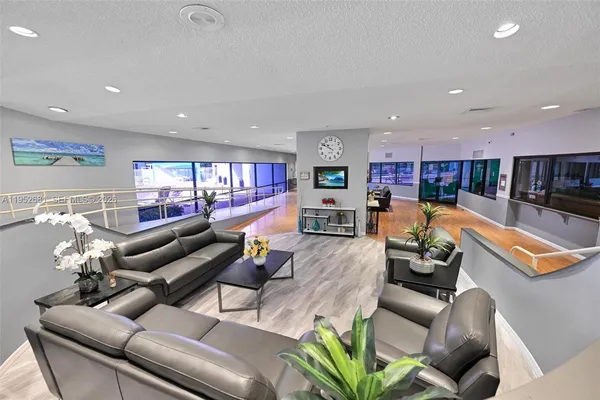 a living room with furniture kitchen view and a potted plant