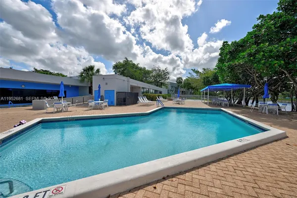 a swimming pool view with a seating space and a garden view