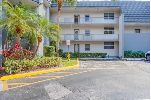 a front view of house with a yard and potted plants