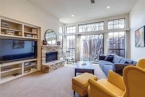 a living room with furniture a fireplace and a large window