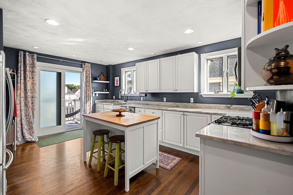 a kitchen with a sink a stove cabinets and wooden floor
