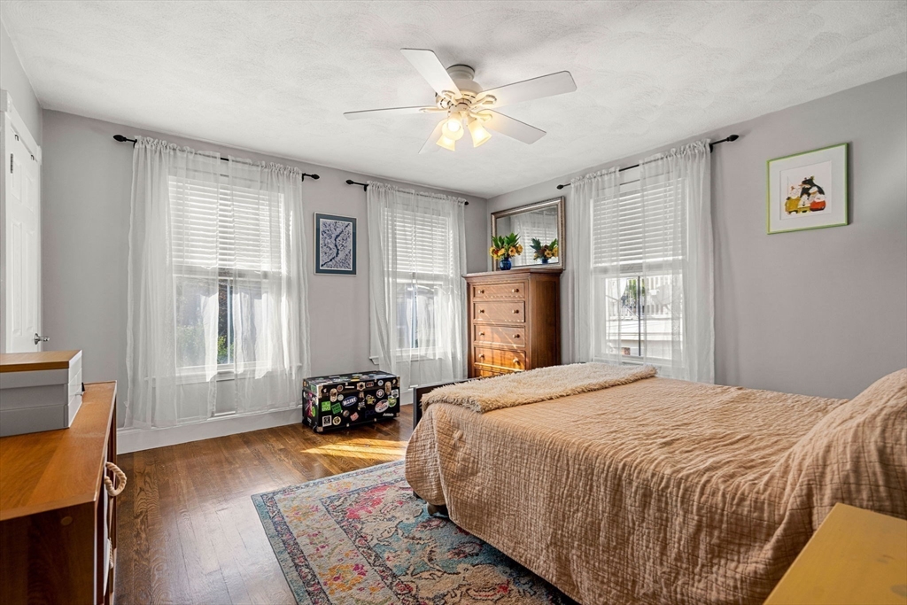 189 Burrill Street, Unit 2 Swampscott, MA 01907 - Photo 7 of 21 a bedroom with a bed and wooden floor