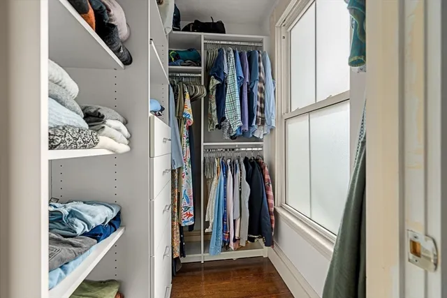 a view of walk in closet with clothes and shoes