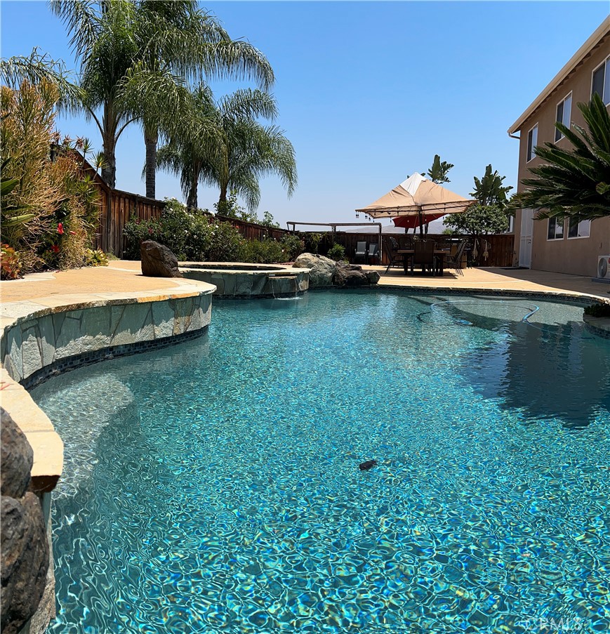 8634 Hunt Canyon Road Corona, CA 92883 - Photo 3 of 31 a view of a swimming pool with a lawn chairs under palm trees