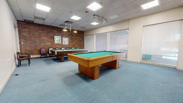 a room with pool table and windows