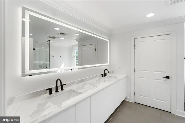 a bathroom with a double vanity sink and mirror