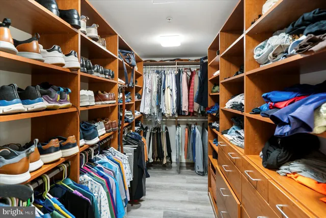 a view of walk in closet with clothes and shoes