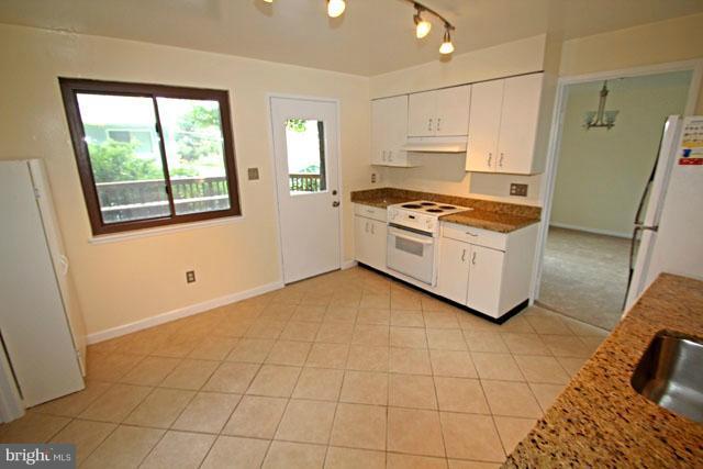 1105 North Rockingham Street Arlington, VA 22205 - Photo 13 of 24 a kitchen with granite countertop a stove a sink and a refrigerator