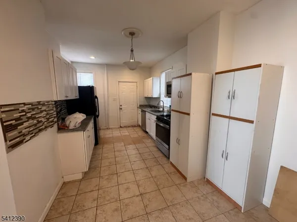 a kitchen with stainless steel appliances granite countertop a refrigerator and a stove