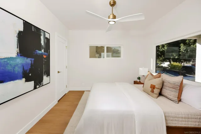 a bedroom with a bed and a painting on the wall