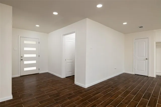 a view of empty room with wooden floor
