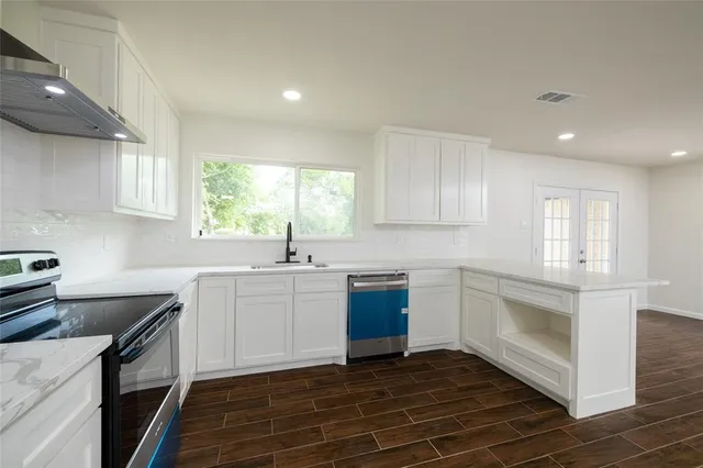 a kitchen with granite countertop white cabinets and white appliances