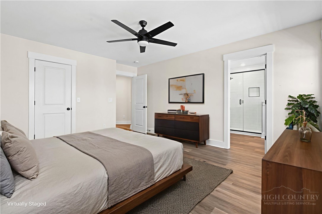 228 Stratford Lane Boone, NC 28607 - Photo 18 of 33 a spacious bedroom with a bed and a chandelier