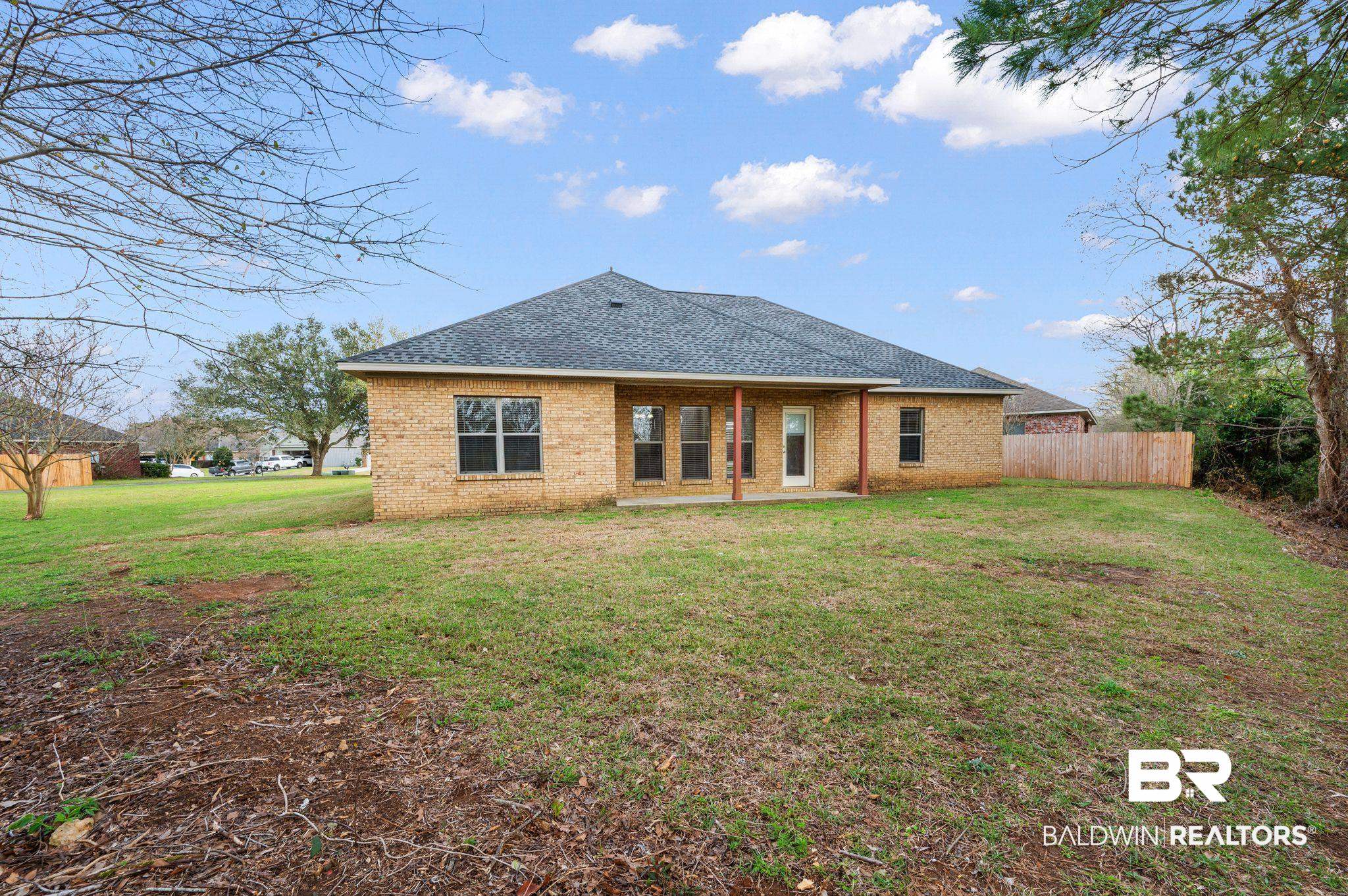 9381 Sable Court Daphne, AL 36526 - Photo 41 of 42 Rear view of house with a shingled roof, brick siding, a lawn, and fence