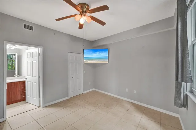 an empty room with windows and fan