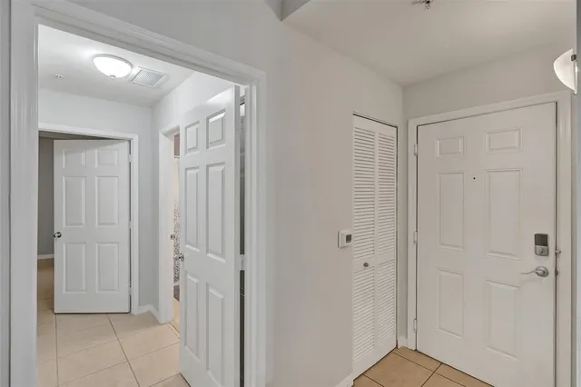 an empty room with windows and ceiling fan