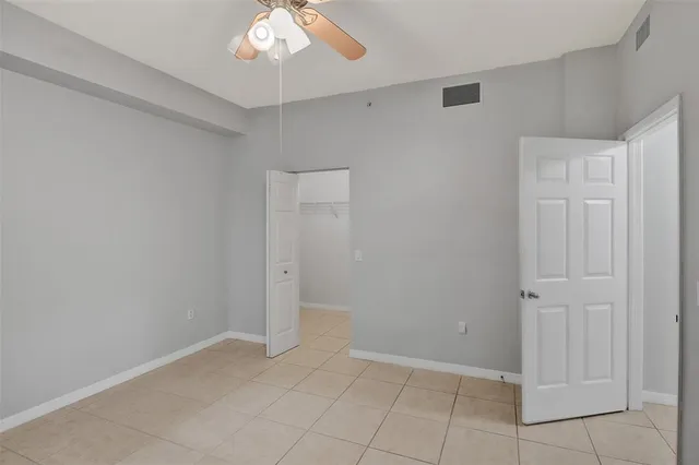 an empty room with fan and entryway