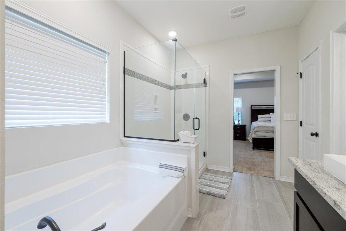 6206 Timberland Ridge Drive Crestview, FL 32539 - Photo 16 of 34 a bathroom with a tub a sink a mirror and a shower