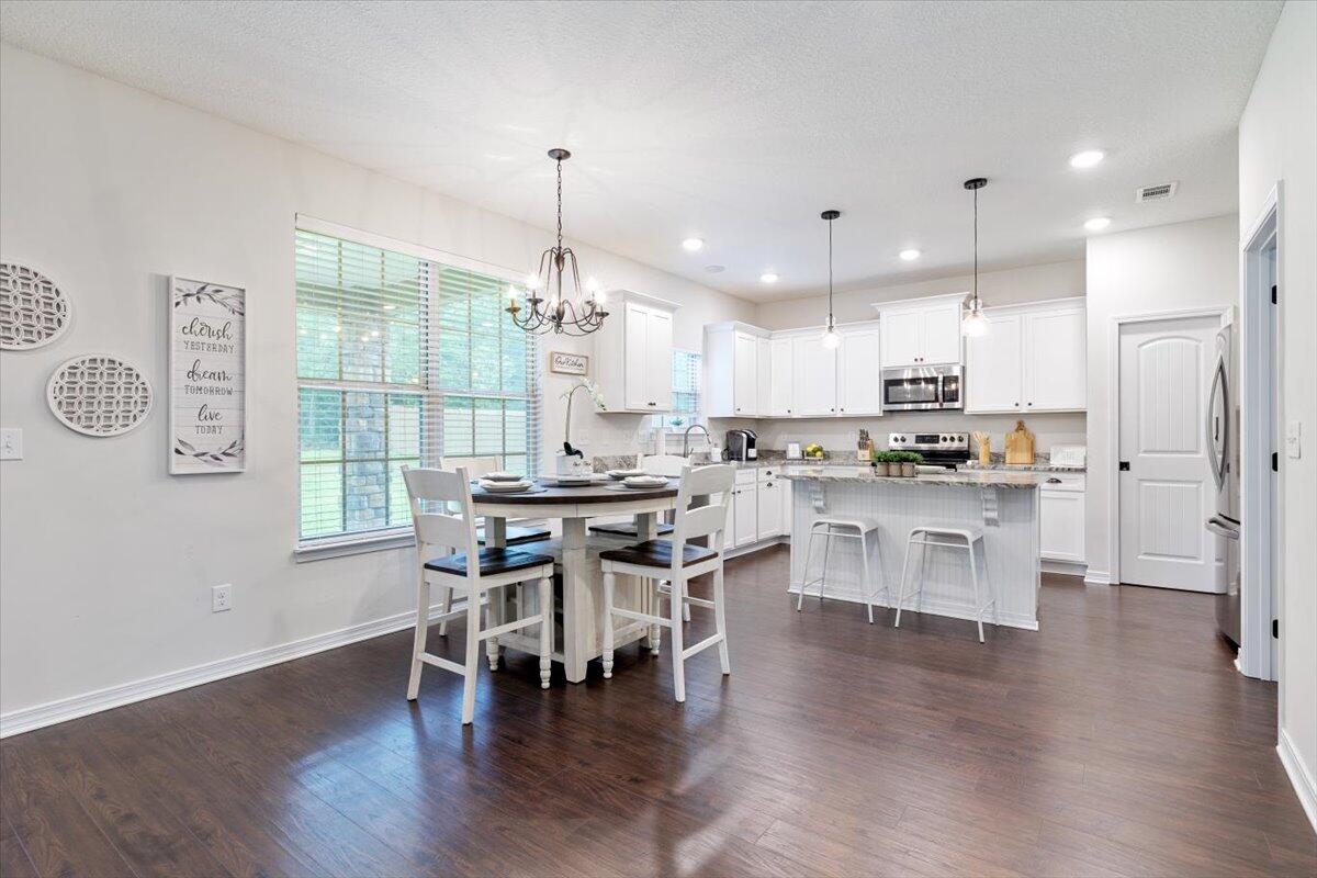 6206 Timberland Ridge Drive Crestview, FL 32539 - Photo 25 of 34 a kitchen with stainless steel appliances a dining table chairs stove refrigerator and cabinets