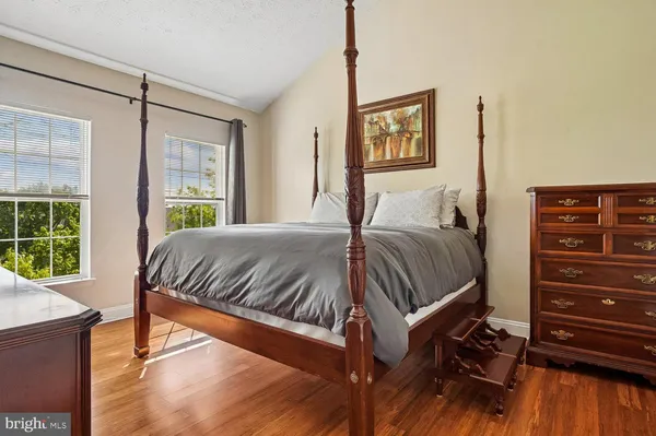 a bedroom with a bed and painting on the wall