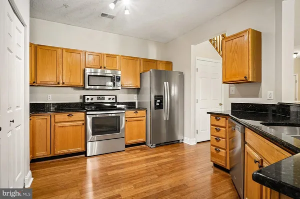 a kitchen with granite countertop a sink a stove and a window