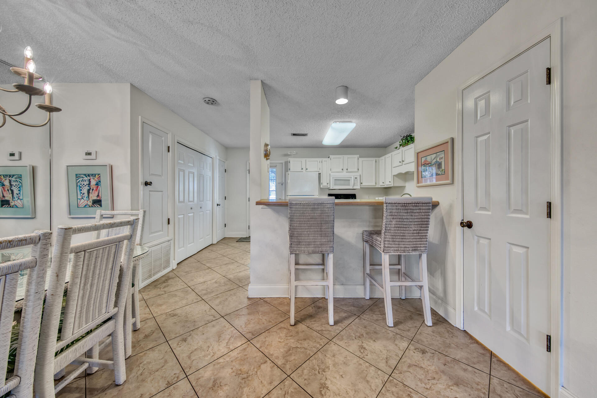 241 Ellis Road, Unit 4 Miramar Beach, FL 32550 - Photo 9 of 30 a dining room with stainless steel appliances kitchen island granite countertop a table and chairs