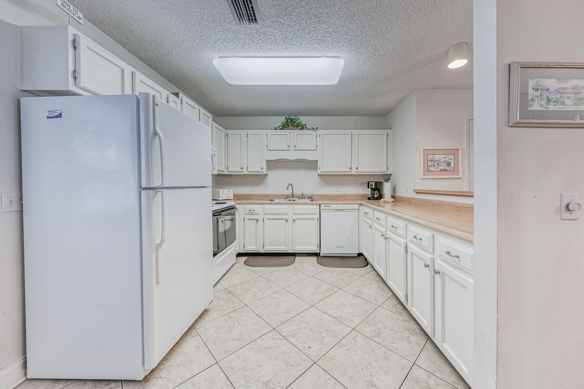 241 Ellis Road, Unit 4 Miramar Beach, FL 32550 - Photo 10 of 30 a kitchen with white cabinets a sink appliances and a window