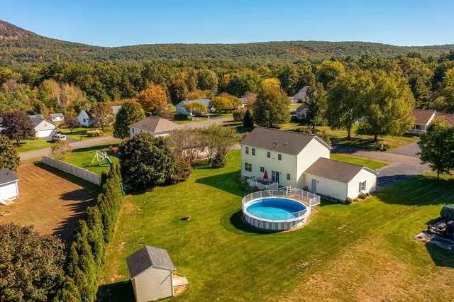an aerial view of a house with swimming pool and big yard