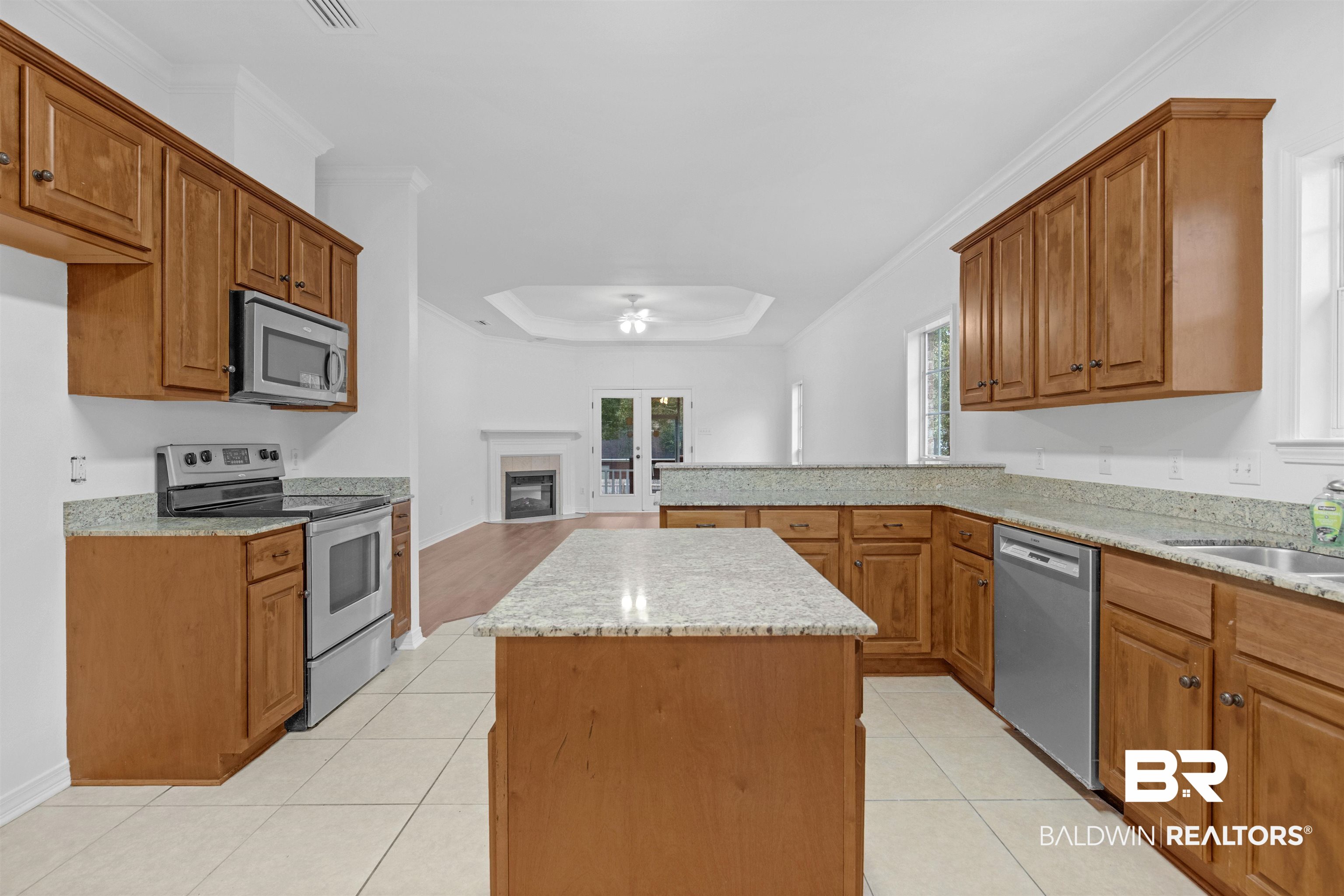 1007 Linlen Avenue Mobile, AL 36609 - Photo 7 of 21 Kitchen featuring sink, appliances with stainless steel finishes, ornamental molding, light tile patterned floors, and a kitchen island