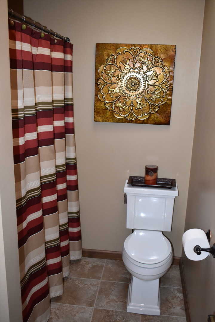 1413 East 550th Road Lostant, IL 61334 - Photo 15 of 37 a bathroom with a toilet and a shower curtain