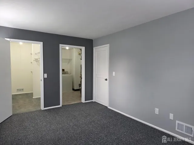 an empty room with closet and a bathroom