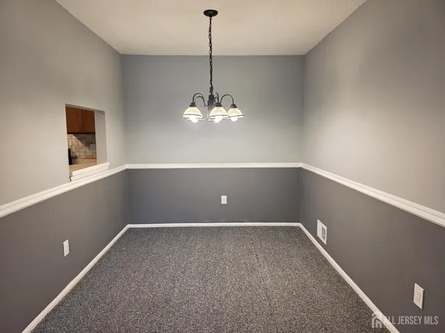 a view of a room with window and chandelier fan