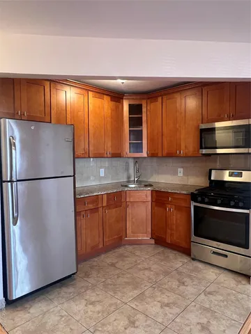 a kitchen with stainless steel appliances granite countertop a refrigerator sink and cabinets