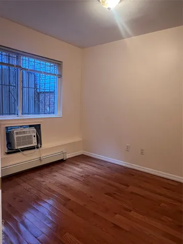 a view of a room with wooden floor and a window