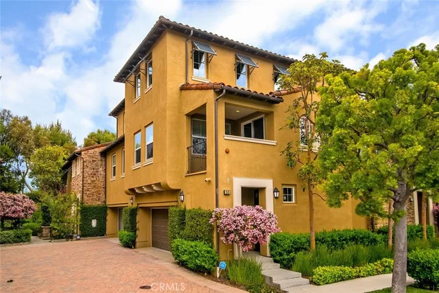 a front view of a house with plants and trees