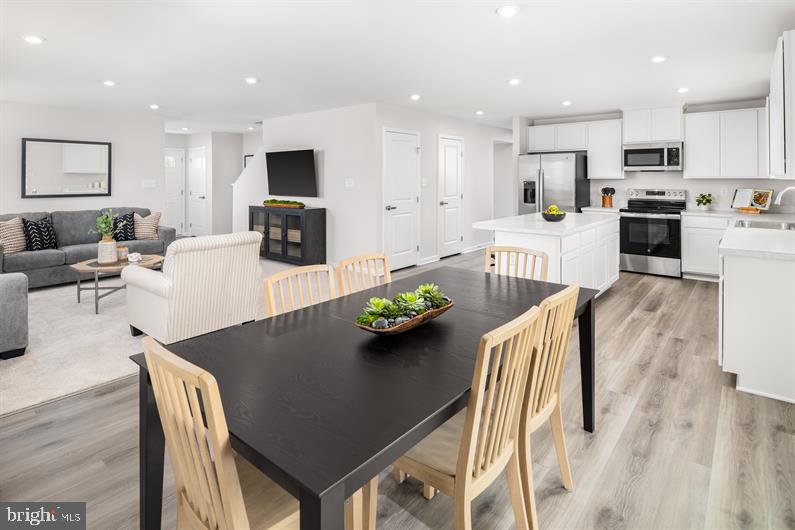 6416 Draft Way, Unit HAZEL Fredericksburg, VA 22407 - Photo 8 of 26 a living room with stainless steel appliances furniture dining table and wooden floor