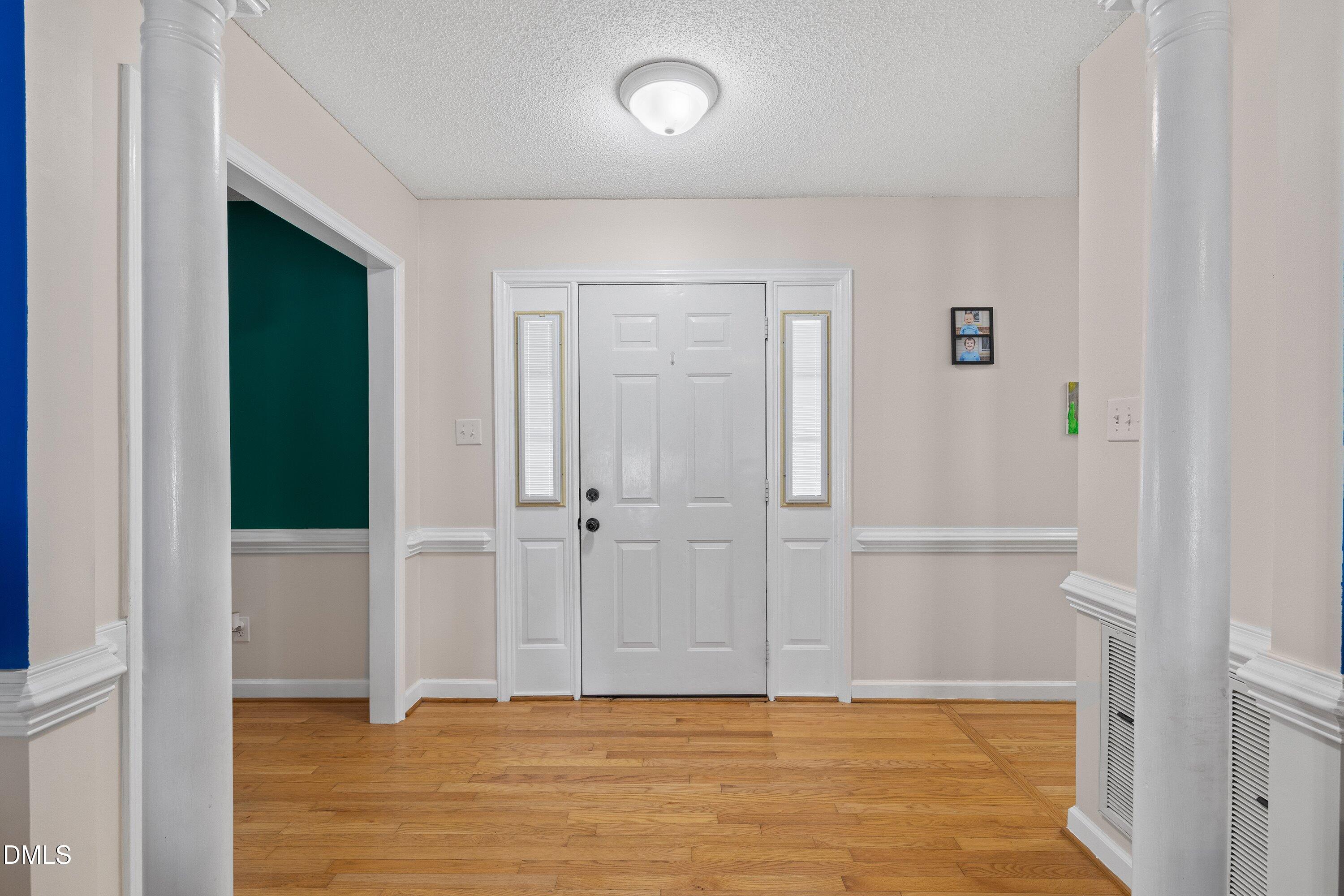 724 Iris Bryant Road Dunn, NC 28334 - Photo 6 of 22 an empty room with wooden floor and windows