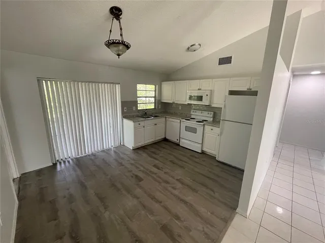 a kitchen with white cabinets and white appliances