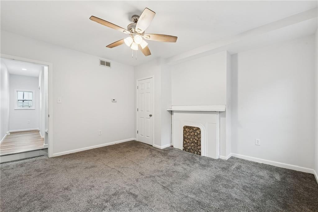 4416 Woolslayer Way Pittsburgh, PA 15224 - Photo 13 of 21 an empty room with fireplace and fan
